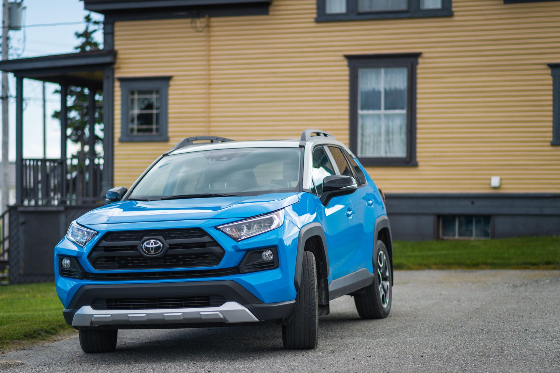Niebieski SUV Toyota RAV4 zaparkowany przed domem