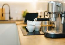 Najlepsze ekspresy do kawy do domu – ranking praktycznych modeli na 2024 Nowoczesny ekspres do kawy na kuchennym blacie z filiżankami