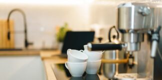 Nowoczesny ekspres do kawy na kuchennym blacie z filiżankami