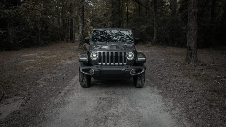 Jeep Wrangler na leśnym szlaku terenowym widziany z przodu
