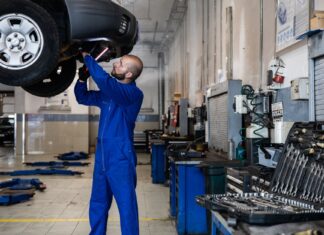 Najczęstsze usterki Toyoty Auris Hybrid – co psuje się w używanych egzemplarzach? Mechanik sprawdza podniesiony samochód w warsztacie samochodowym