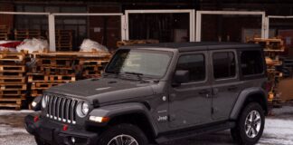 Ile pali Jeep Wrangler? Spalanie wersji benzynowych, diesla i 4xe Szary Jeep Wrangler zaparkowany na śniegu wśród drewnian